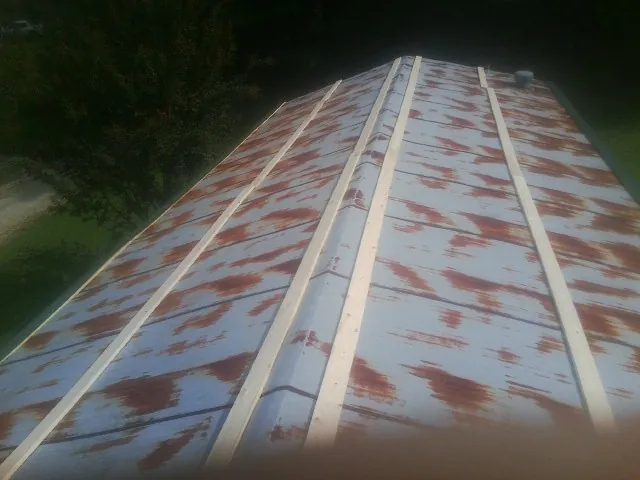 Rusted metal roof panels with new wood purlins before replacement — Storm Damage Roof Repair in Wallisville by Roofing Brothers